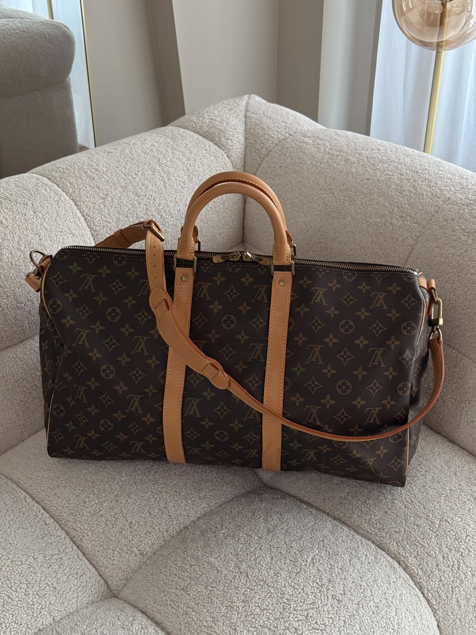 Klassisk Louis Vuitton Keepall 50 Bandoulière i ikonisk Monogram canvas med skinn og gullfarget hardware. En tidløs og praktisk reiseveske med skulderrem.