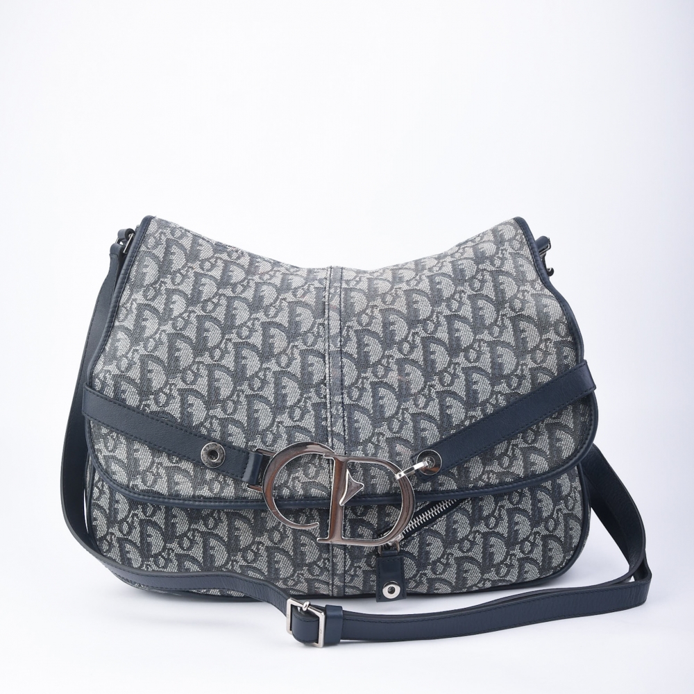 Dior-veske i blå Oblique Canvas – laget i Italia i 1980. Denne modellen representerer Diors ikoniske signaturmønster fra perioden, og er et ekte vintagefunn med alle originale deler bevart. Et elegant og sjeldent samleobjekt som passer både til daglig br