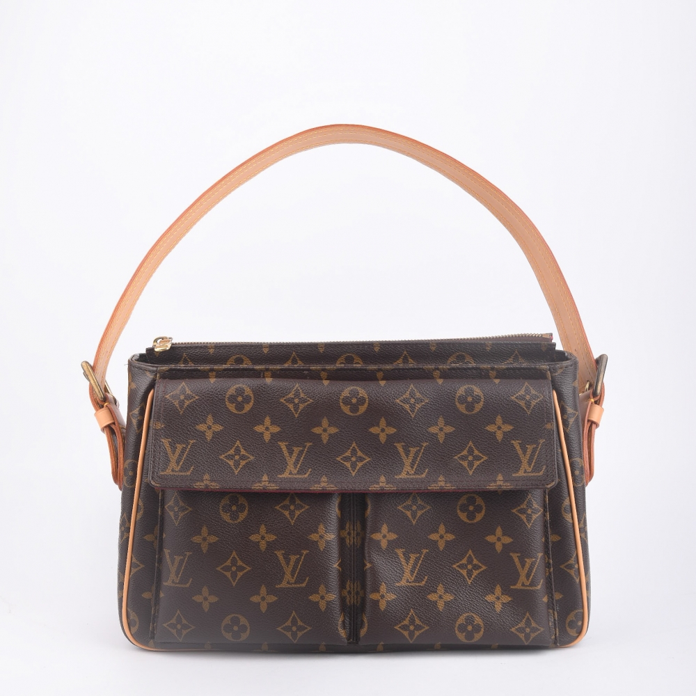 En romslig og ettertraktet Louis Vuitton Cité GM fra 2003, laget i klassisk brun monogram canvas med gullfarget hardware og helt nytt skinn. Produsert i Frankrike, og kjent for sin strukturerte fasong, generøse plass og tidløse uttrykk – en perfekt veske 