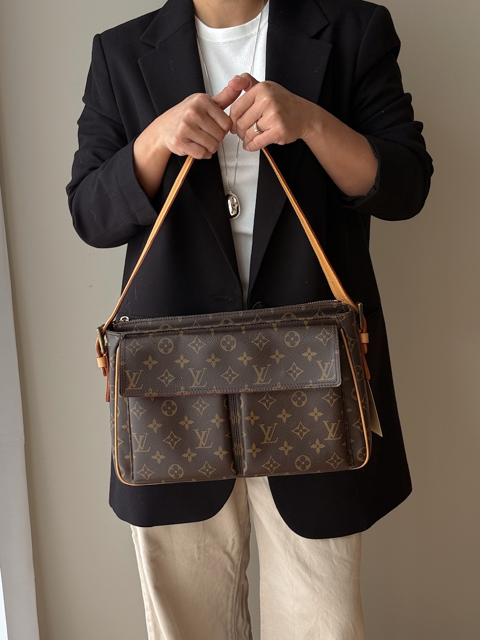 En romslig og ettertraktet Louis Vuitton Cité GM fra 2003, laget i klassisk brun monogram canvas med gullfarget hardware og helt nytt skinn. Produsert i Frankrike, og kjent for sin strukturerte fasong, generøse plass og tidløse uttrykk – en perfekt veske 