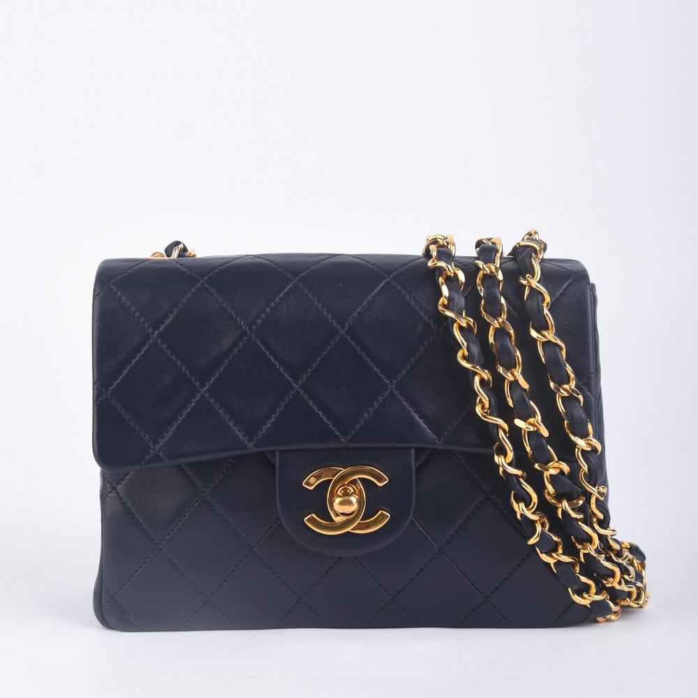 Chanel Mini Flap i mørk marineblå lammeskinn med 24 K gullbelagt hardware og alle originale deler. Produsert i Frankrike – en liten, raffinert veske som kombinerer vintage-kvalitet med Chanels ikoniske design og tidløst uttrykk.