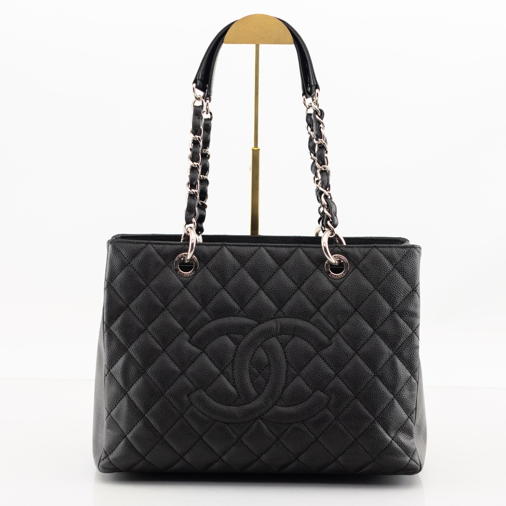 Klassisk Chanel GST (Grand Shopping Tote) i slitesterkt sort caviar-skinn med gullfarget hardware. En av Chanels mest ettertraktede tote-vesker med elegant og tidløst uttrykk.