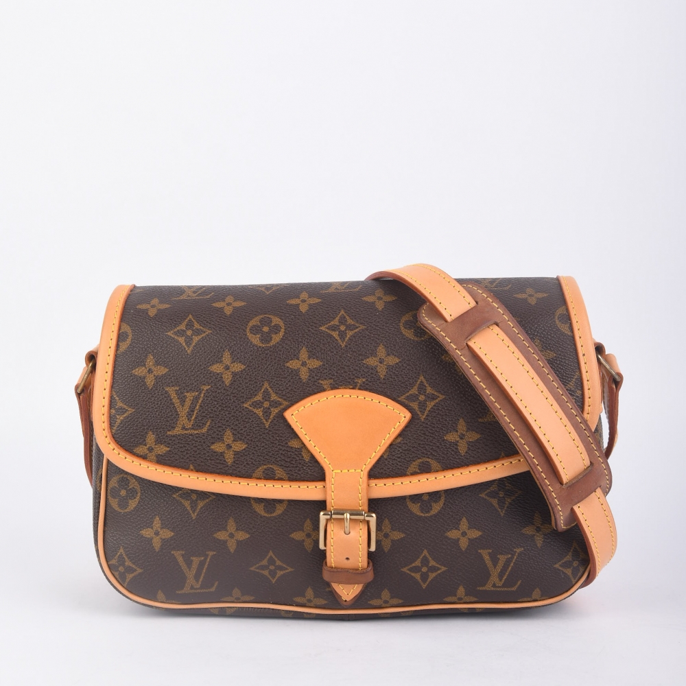 En klassisk og ettertraktet Louis Vuitton Sologne fra 1999, laget i ikonisk brun monogram canvas med gullfarget hardware og helt nytt skinn. Produsert i Frankrike, og kjent for sin elegante, strukturert form og praktiske crossbody-design 