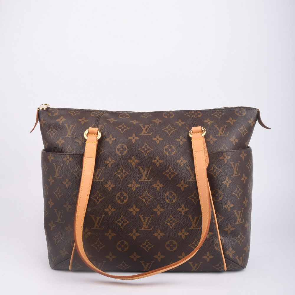 En klassisk og funksjonell Louis Vuitton Totally fra 2012, laget i brun monogram canvas med gullfarget hardware og helt nytt skinn. Produsert i USA, og kjent for sitt praktiske design med romslig innside og ikoniske side­lommer