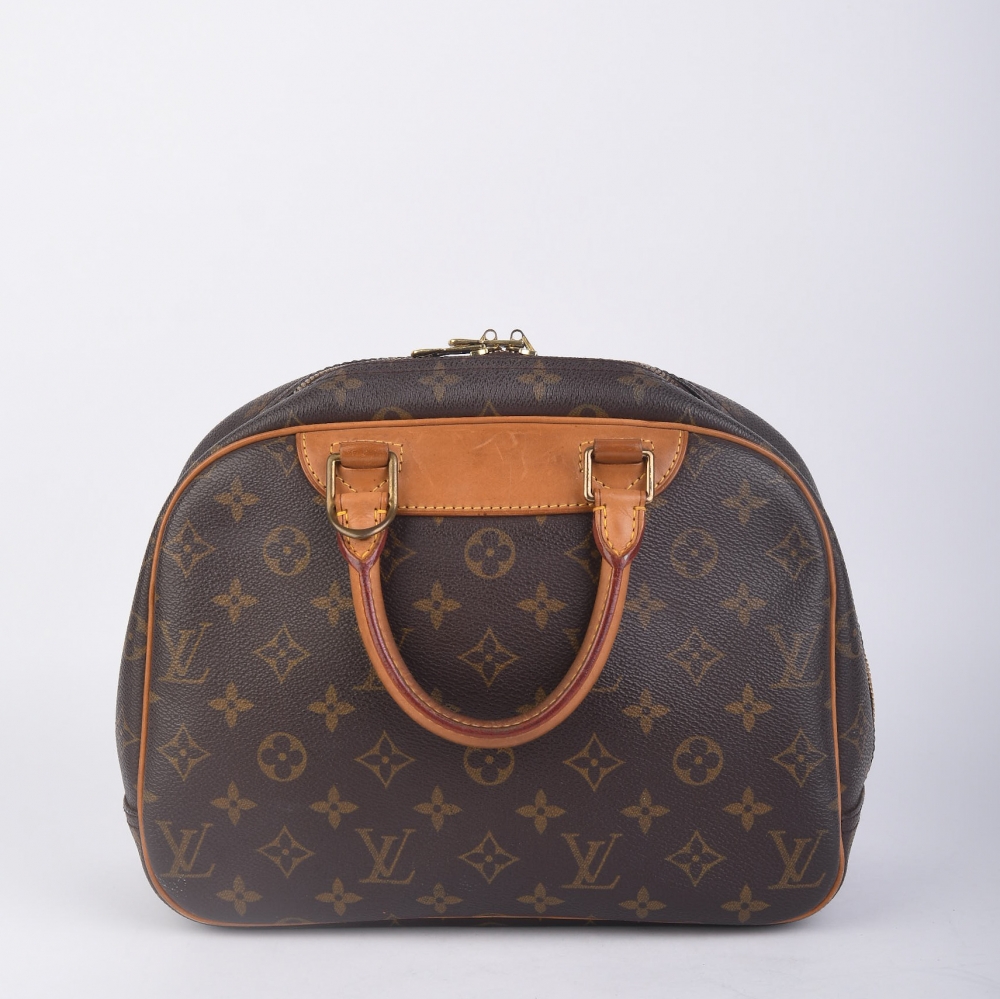 Louis Vuitton Trouville i brun monogram canvas med gulltonet hardware og alle originale deler. Produsert i Frankrike – en kompakt og strukturert veske med tidløs Louis Vuitton-stil, kjent for sin praktiske form og raffinerte detaljer 