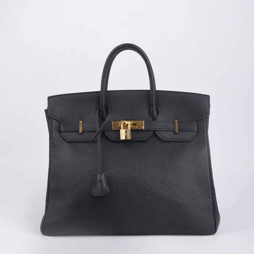 Hermès Birkin HAC 32 i Clemence-skinn og 24 k gullforgylt hardware er et mesterverk i fransk håndverk. Den dype Bleu Nuit-tonen fremhever modellens rene linjer og tidløse eleganse – et symbol på diskret luksus og kompromissløs kvalitet.
