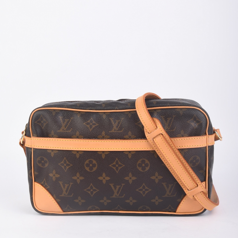 En elegant Louis Vuitton Compeigne Clutch fra tidlig 1990-tall, laget i ikonisk brun monogram canvas med gullfarget hardware og nytt skinn. Produsert i Frankrike i 1991 – en tidløs modell som kombinerer klassisk Louis Vuitton-design med moderne funksjonal